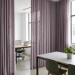 plum-toned linen-textured drapery panels used as a soft interior room divider in a modern office space